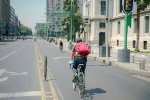 Radfahrer auf einer innerstädtischen Fahrspur mit grünen Ampelmasten