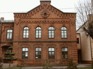 Historische rote Backsteinfassade mit großen Sprossenfenstern